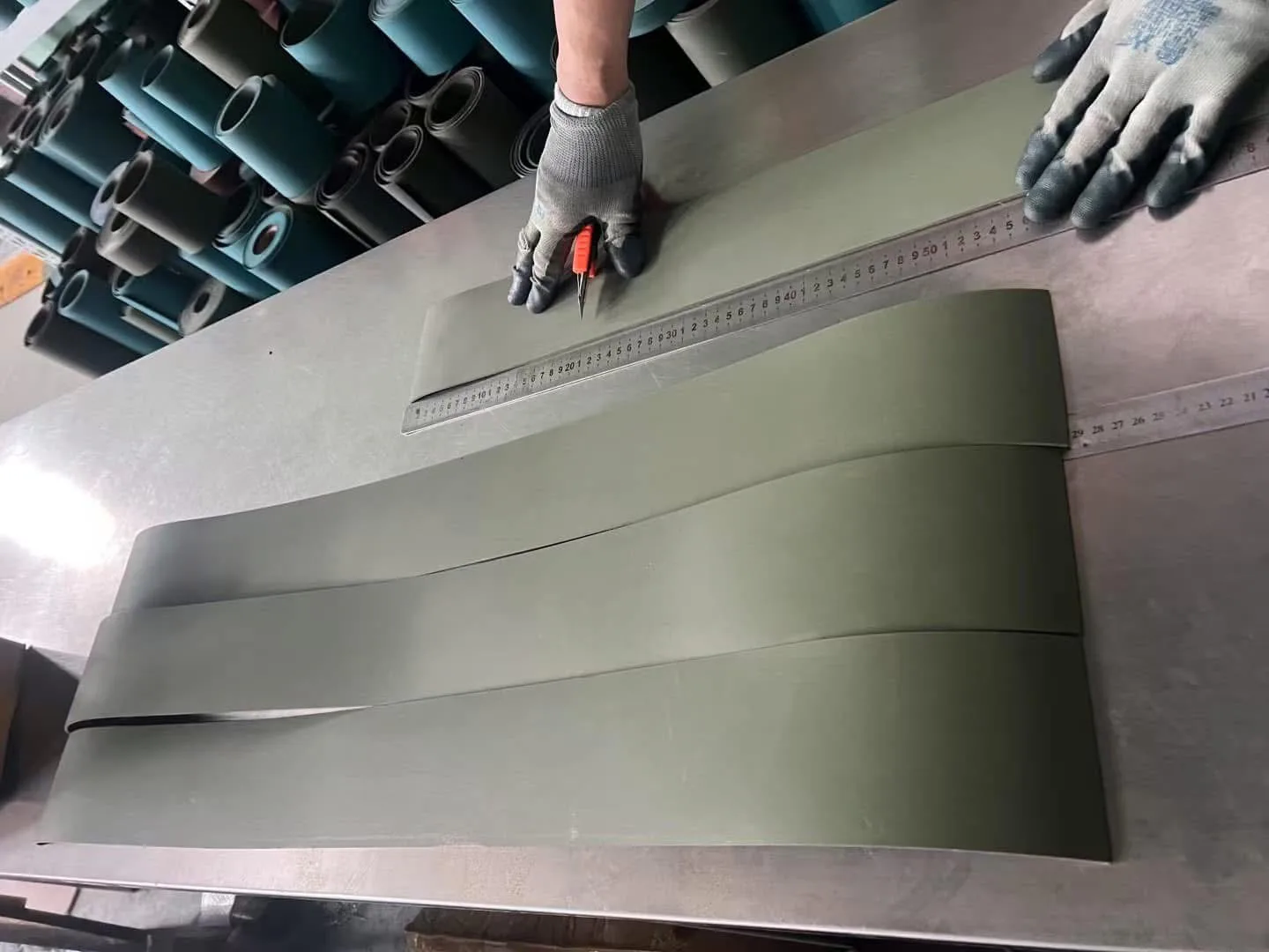 A Turcite B sheet being measured against a steel rule and cut to size with a utility knife.