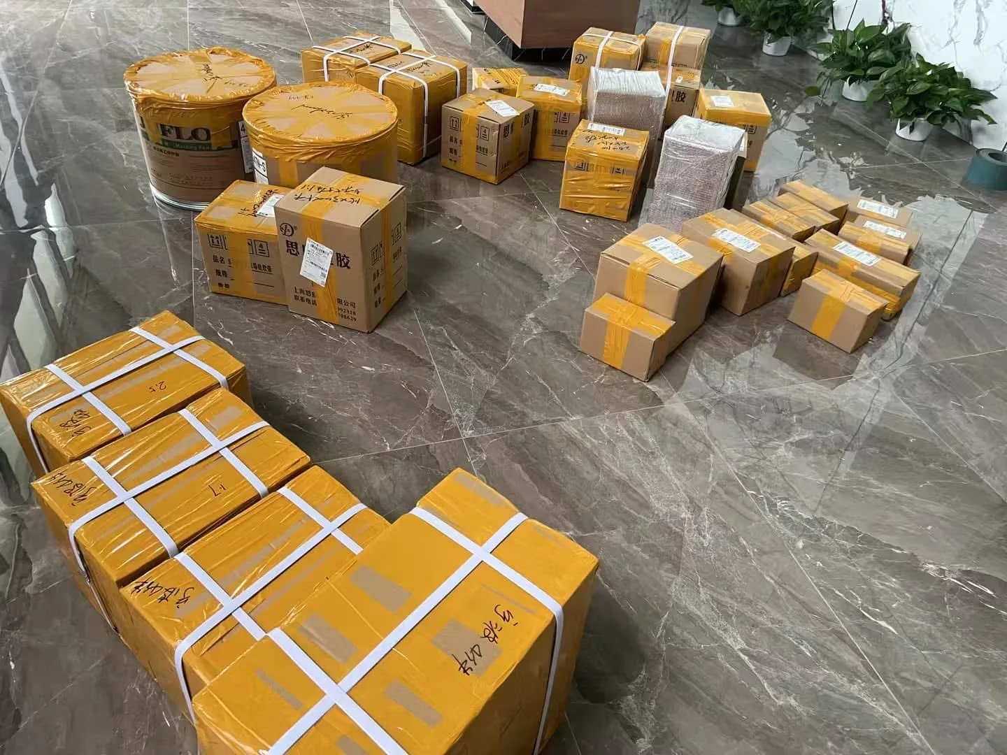 Cartons taped and stacked ready for dispatch, with adhesive drums alongside.