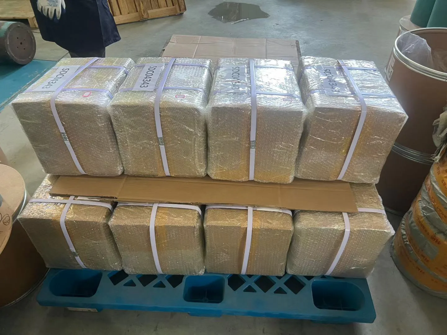 A pallet of stretch-wrapped and strapped sheet bundles prepared for export.